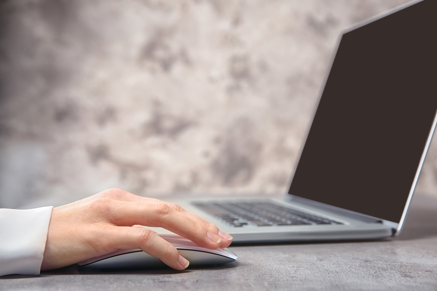 Technical support dispatcher working with laptop on grey table